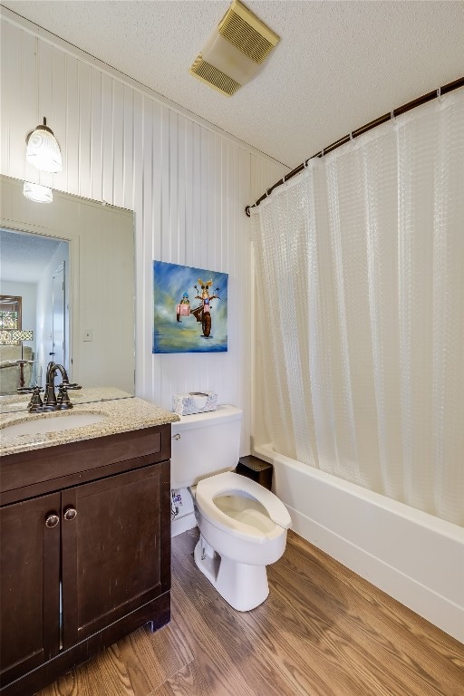 full bath with toilet, wood finished floors, vanity, visible vents, and shower / bathtub combination with curtain