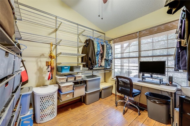 office with light wood-style floors, ceiling fan, vaulted ceiling, and a textured ceiling