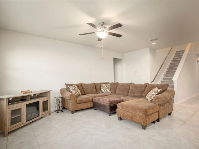 245 Tulum Ter, Leander, TX 78641 - living room with a ceiling fan, light tile patterned flooring, and stairway