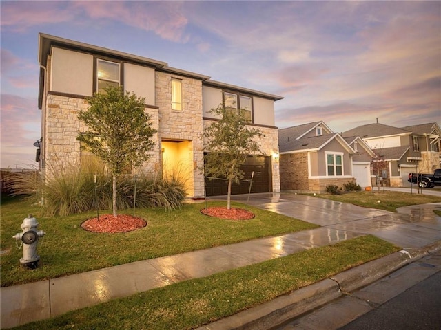 245 Tulum Ter, Leander, TX 78641 - view of front facade with stone siding, driveway, a garage, a front yard, and stucco siding
