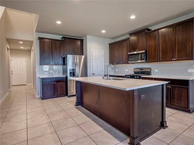 245 Tulum Ter, Leander, TX 78641 - kitchen featuring stainless steel appliances, backsplash, light tile patterned floors, dark brown cabinets, and recessed lighting