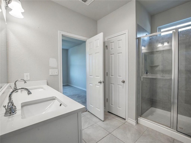 245 Tulum Ter, Leander, TX 78641 - bathroom featuring a stall shower, double vanity, and tile patterned flooring
