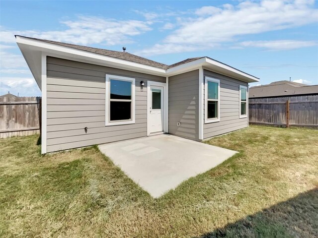 back of house with a patio area and a yard