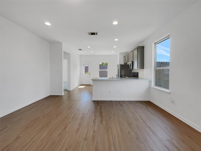 unfurnished living room with sink and hardwood / wood-style floors