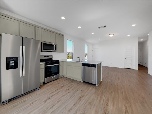 kitchen featuring appliances with stainless steel finishes, sink, gray cabinetry, and light hardwood / wood-style floors