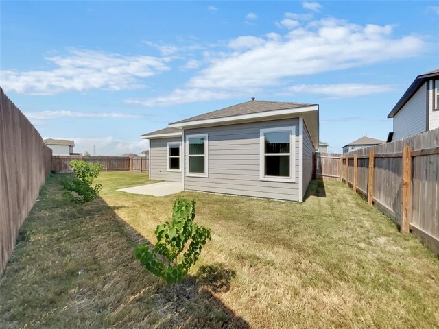 rear view of house featuring a lawn and a patio area