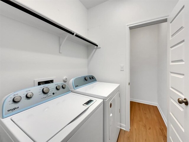 washroom with light hardwood / wood-style flooring and washing machine and clothes dryer