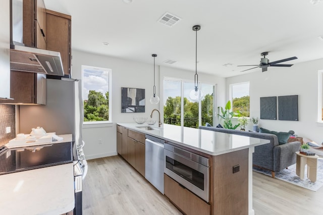 kitchen featuring a wealth of natural light, pendant lighting, sink, and appliances with stainless steel finishes