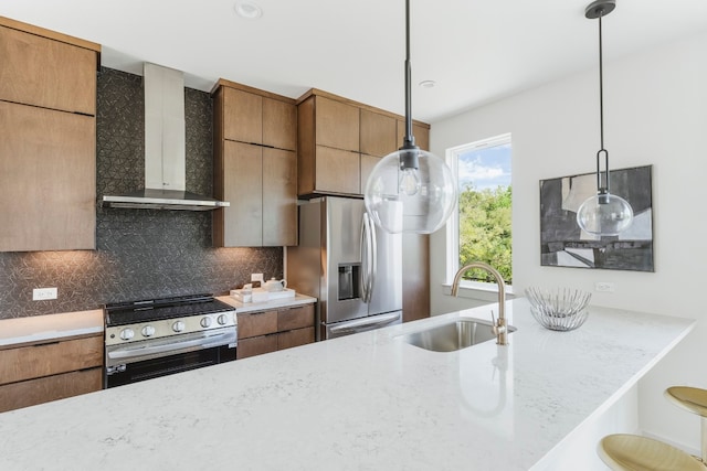 kitchen featuring a healthy amount of sunlight, stainless steel appliances, sink, and wall chimney range hood