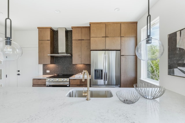 kitchen featuring wall chimney exhaust hood, a healthy amount of sunlight, stainless steel appliances, and sink