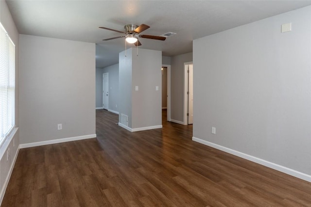 unfurnished room with a ceiling fan, visible vents, baseboards, and wood finished floors