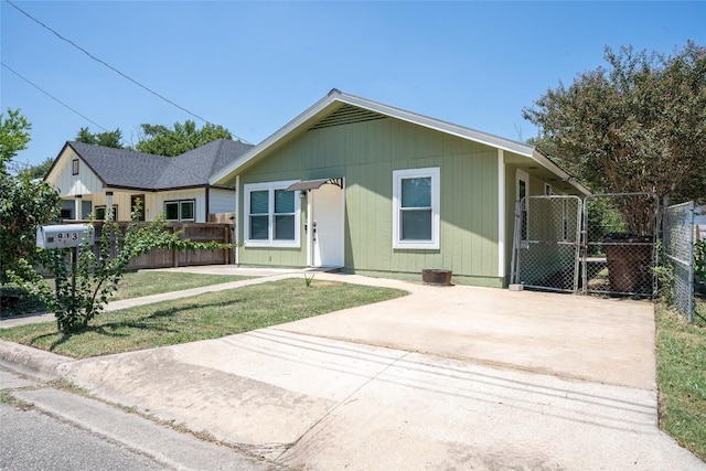 view of front of home with a gate, fence, and a front lawn