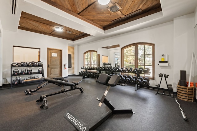 gym with wood ceiling and a tray ceiling