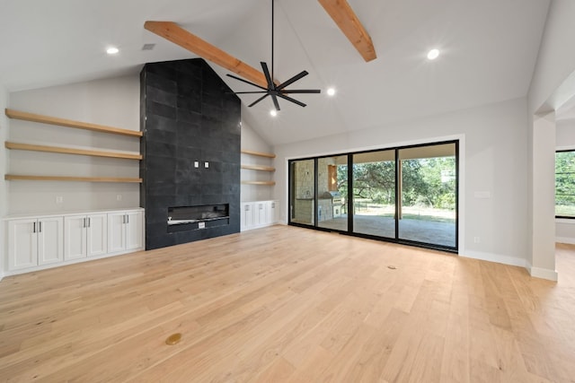 unfurnished living room with a fireplace, light hardwood / wood-style flooring, beam ceiling, high vaulted ceiling, and ceiling fan