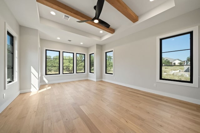 spare room with a tray ceiling, light hardwood / wood-style flooring, beam ceiling, and ceiling fan