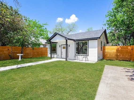 rear view of property with a patio area and a yard