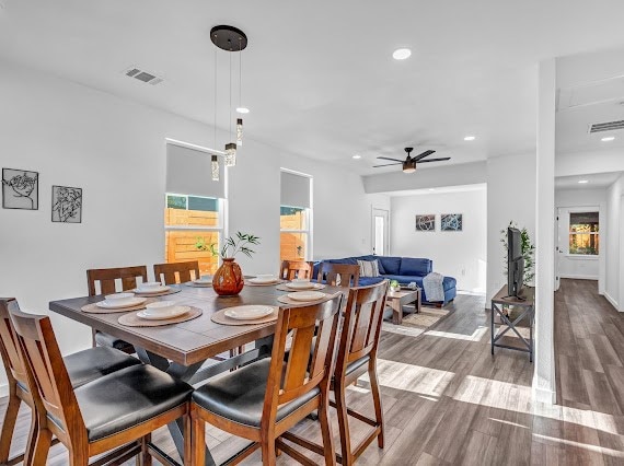 dining area with wood-type flooring and ceiling fan