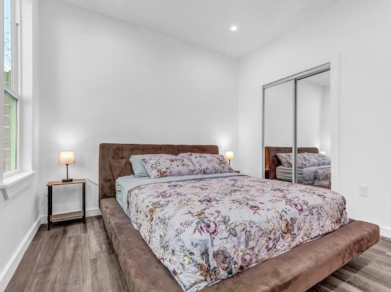 bedroom with a closet and hardwood / wood-style flooring