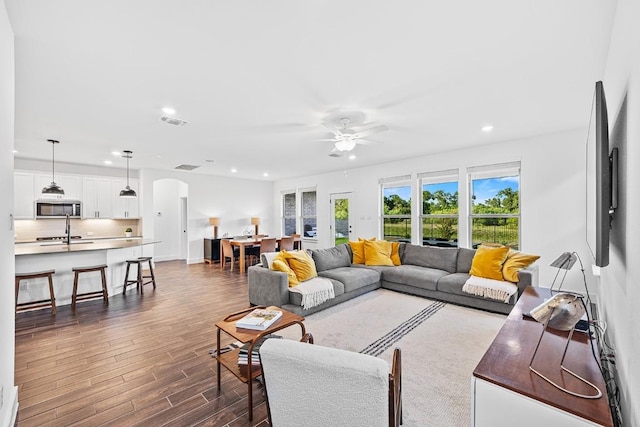 living room with ceiling fan and dark hardwood / wood-style floors