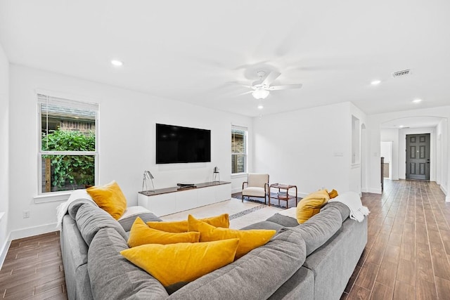 living area with visible vents, arched walkways, wood finished floors, and recessed lighting