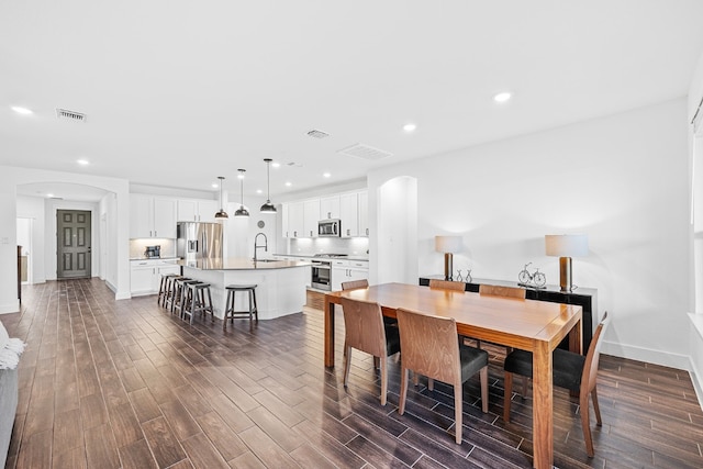 dining space featuring sink and dark hardwood / wood-style flooring