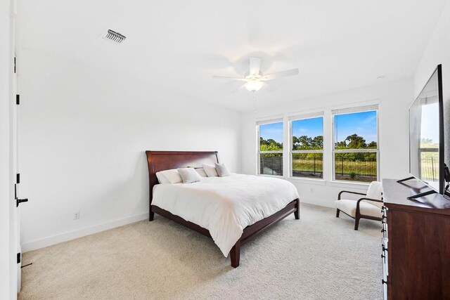 bedroom with ceiling fan and light carpet