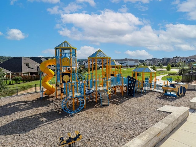 community playground featuring fence and a residential view