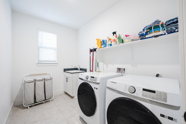 laundry room with washing machine and clothes dryer, cabinets, sink, and light tile patterned floors