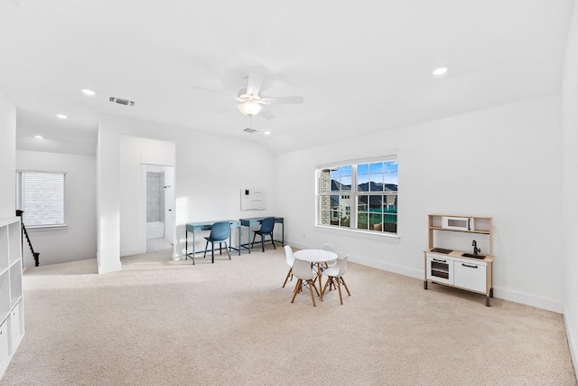 living area with light colored carpet and ceiling fan