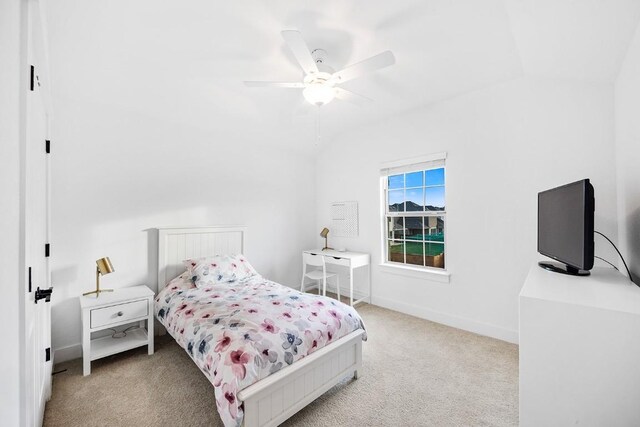 bedroom featuring vaulted ceiling, light colored carpet, and ceiling fan