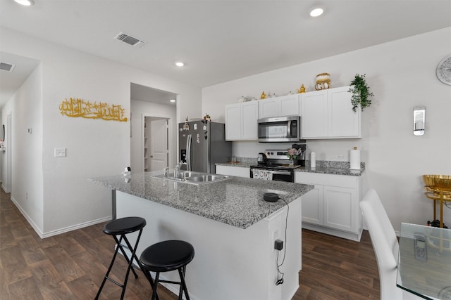 kitchen with sink, dark hardwood / wood-style flooring, stainless steel appliances, and white cabinets