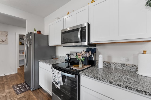 kitchen featuring dark wood-type flooring, light stone countertops, white cabinets, and stainless steel appliances