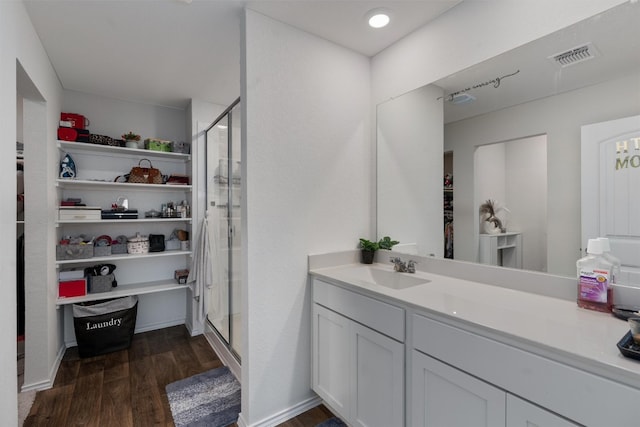 bathroom featuring hardwood / wood-style flooring, a shower with door, and vanity