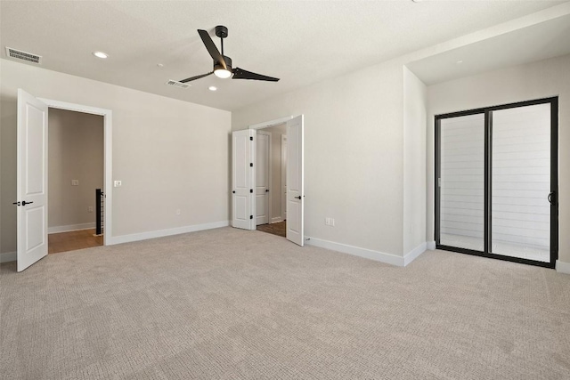 unfurnished bedroom featuring access to exterior, light colored carpet, and ceiling fan