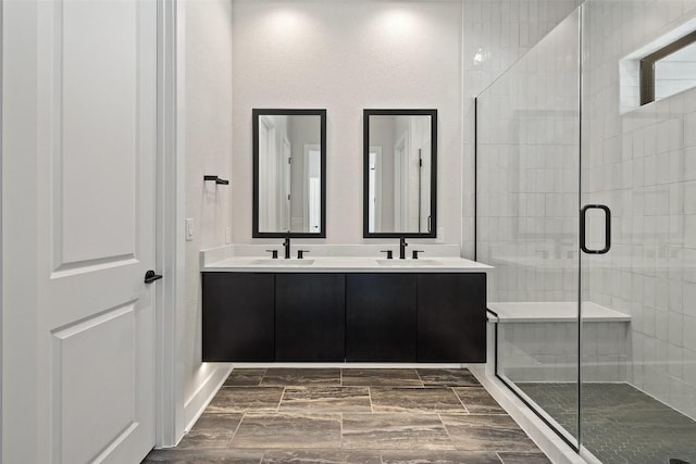 bathroom featuring a shower with door and vanity