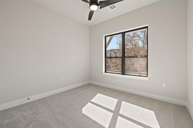 spare room with ceiling fan and light colored carpet