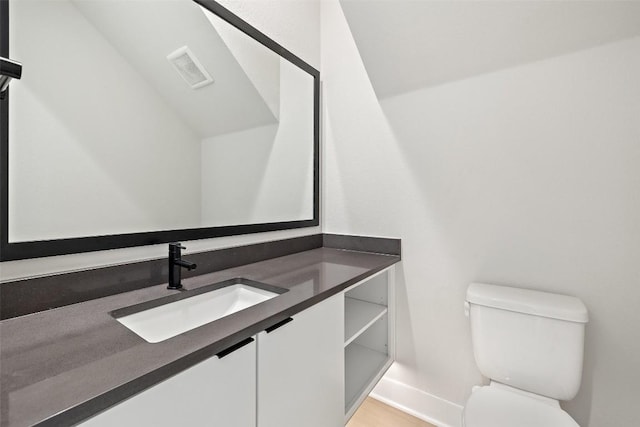 bathroom with wood-type flooring, vanity, and toilet