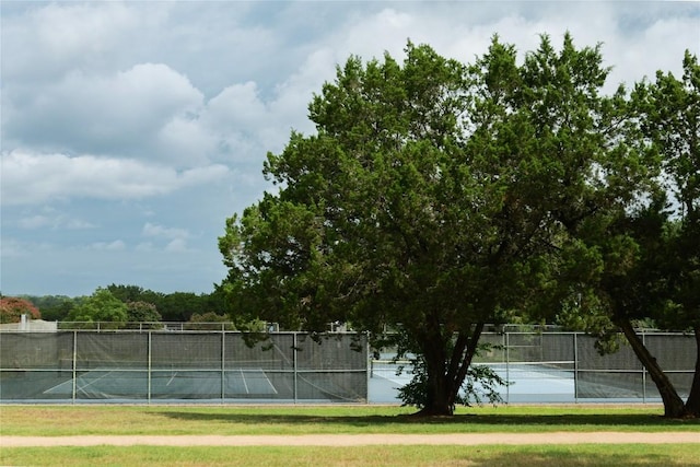 view of sport court with a lawn