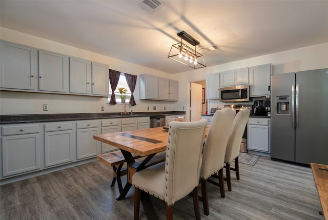 kitchen with gray cabinets, hardwood / wood-style flooring, sink, and appliances with stainless steel finishes