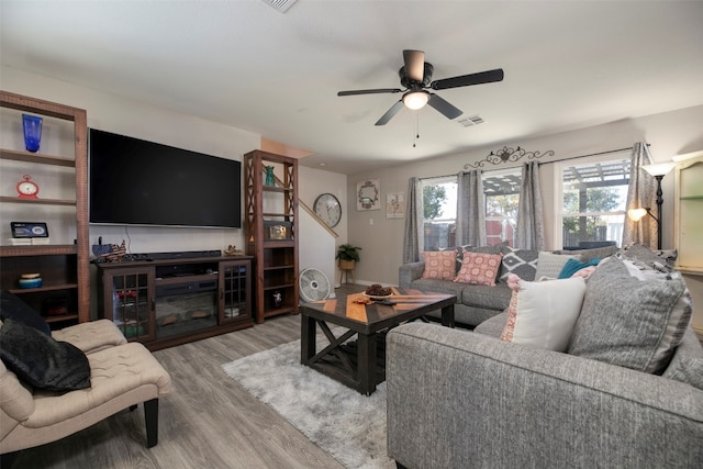 living room with ceiling fan and light wood-type flooring