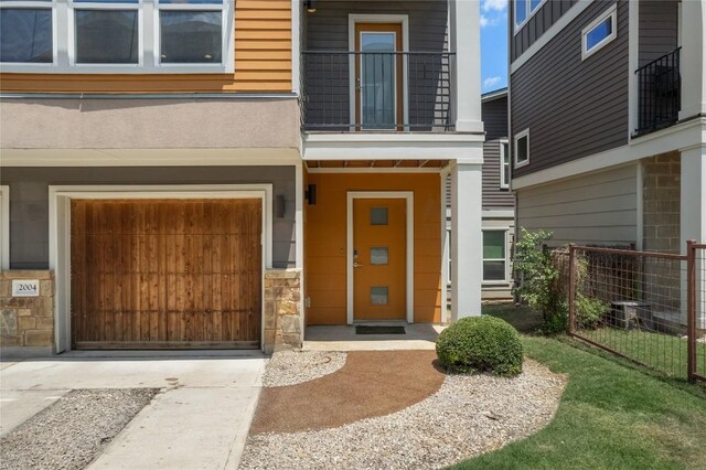 property entrance featuring a garage and a balcony