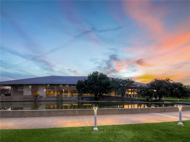 view of home's community featuring a lawn and a water view