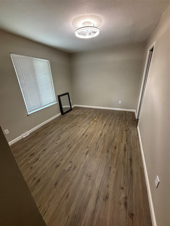 unfurnished room featuring wood-type flooring and a textured ceiling