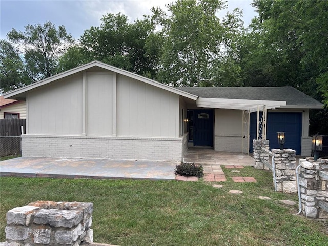 view of front of home featuring fence, a front lawn, and brick siding