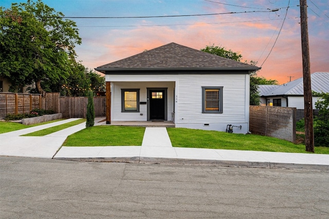 view of front of home featuring covered porch and a yard