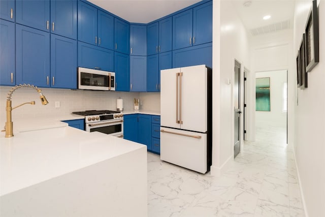 kitchen featuring gas range oven, white refrigerator, light tile patterned floors, tasteful backsplash, and sink