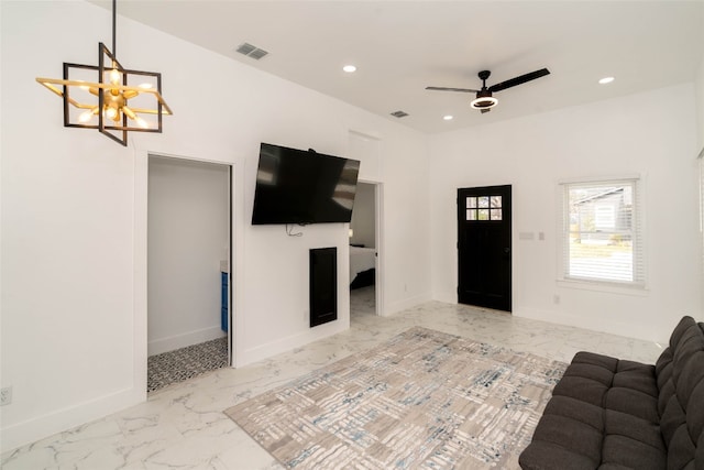 tiled living room featuring ceiling fan with notable chandelier