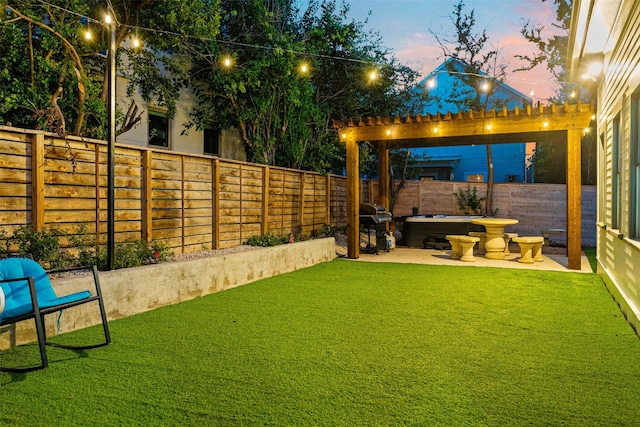 yard at dusk with a hot tub and a patio area