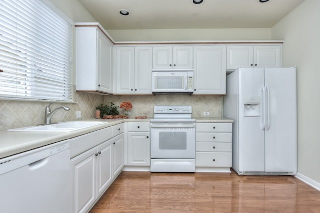 kitchen with white appliances, white cabinets, sink, and light wood-type flooring