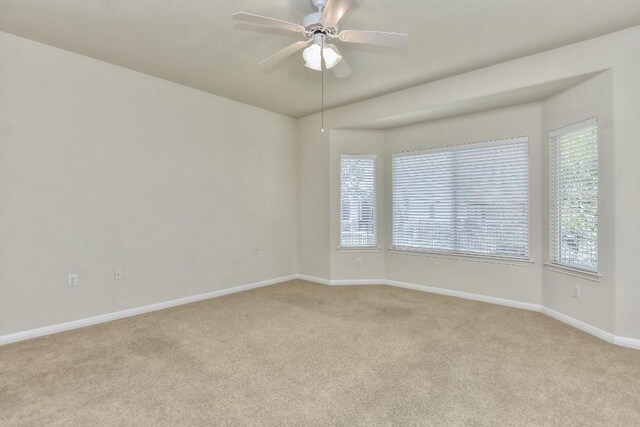 spare room featuring ceiling fan and light colored carpet